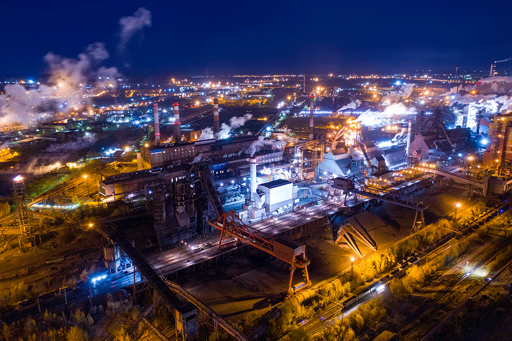 Aerial-view-of-steel-plant-at-night-with-smokestacks-and-fire-blazing-out-of-the-pipe.-Industrial-panoramic-landmark-with-blast-furnance-of-metallurgical-production